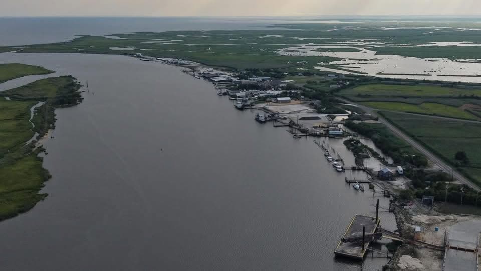 Wide aerial view of a Delaware Bayshore working harbor and marsh channel at dusk